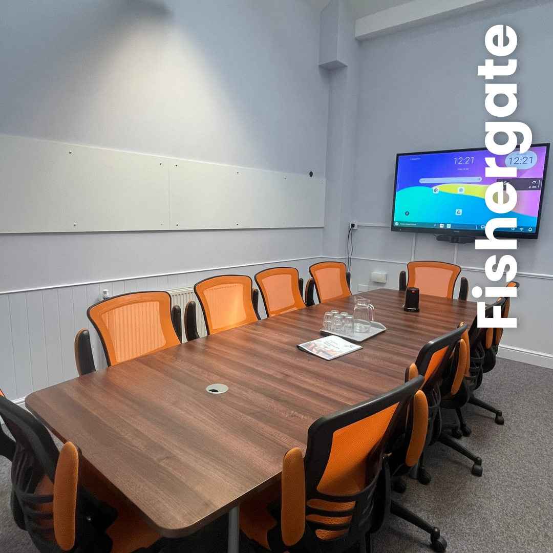Fishergate Wide view TITLE Fishergate- smaller room with board room table and bright orange chairs