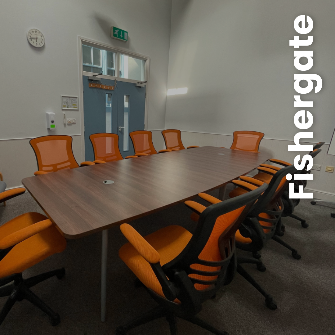 Fishergate- smaller room with board room table and bright orange chairs