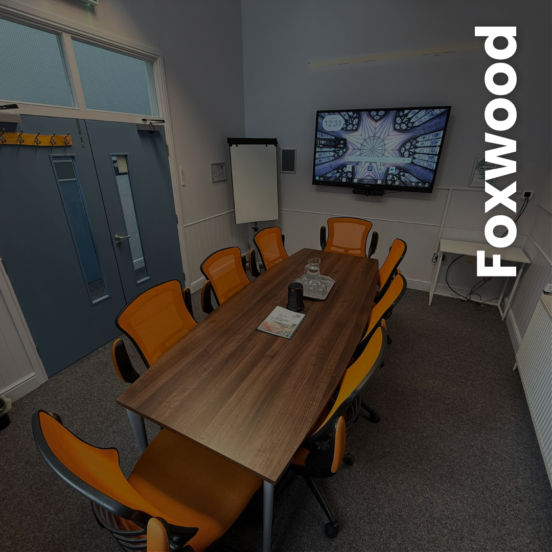 Foxwood Room Image of a medium board room with 8 executive chairs and a multimedia screen